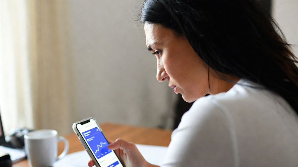 Woman checking bank account on phone before filing for divorce in Texas