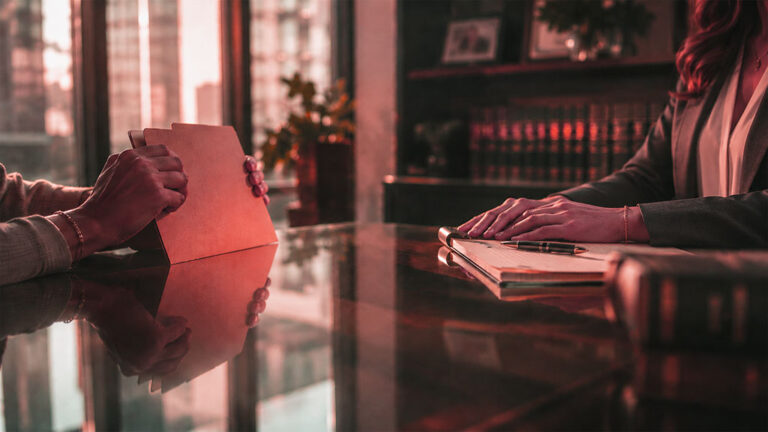 A client's hands gripping a folder across from a divorce attorney at a conference table in a San Antonio law office