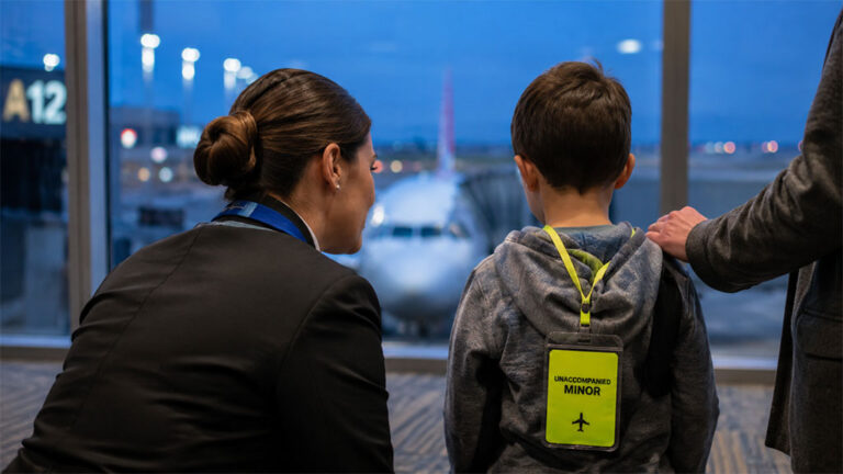 Child wearing an unaccompanied minor lanyard at an airport gate before a custody visitation flight